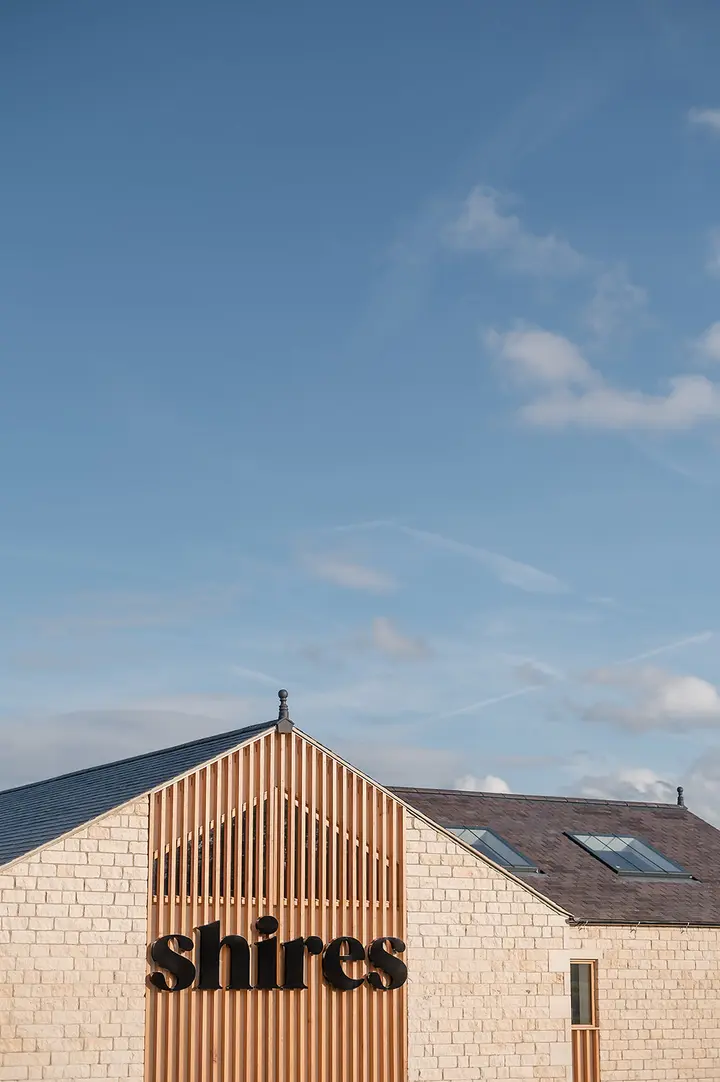 The Shires building with its timber gable and stone walls under a blue sky