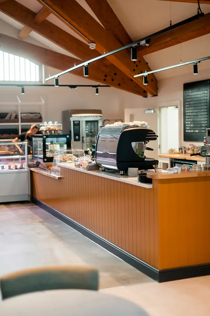 The café counter with its coffee machine and timber front