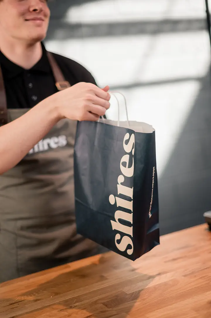 A Shires paper bag handed over the counter